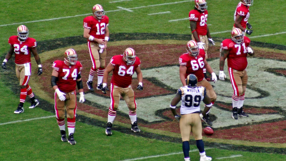 Joueurs des San Francisco 49ers alignés face à un adversaire sur le terrain
