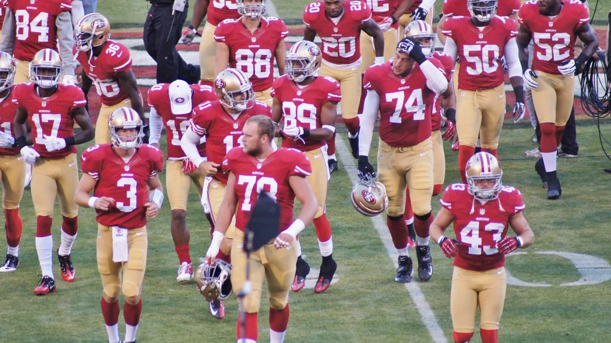 Joueurs des San Francisco 49ers en maillot rouge réunis sur le terrain