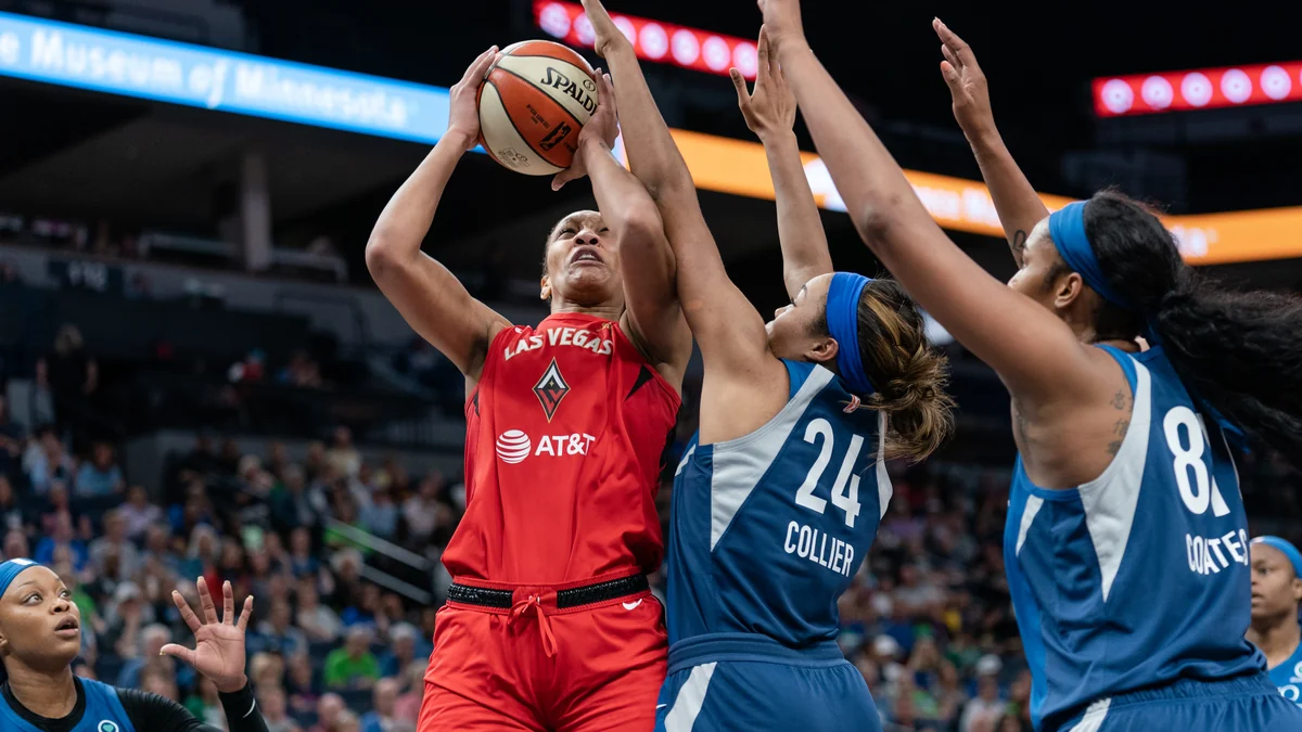 A’ja Wilson arremessa com a camisa vermelha das Las Vegas Aces entre duas defensoras do Minnesota Lynx.