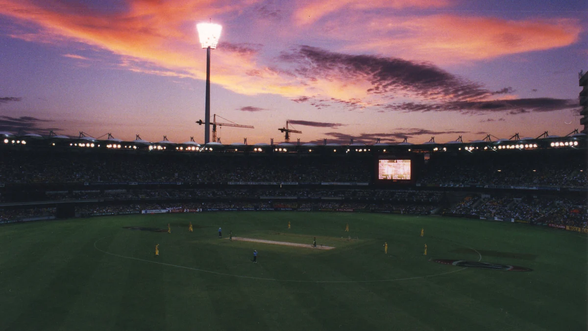 Stade de cricket éclairé au coucher du soleil pendant un match