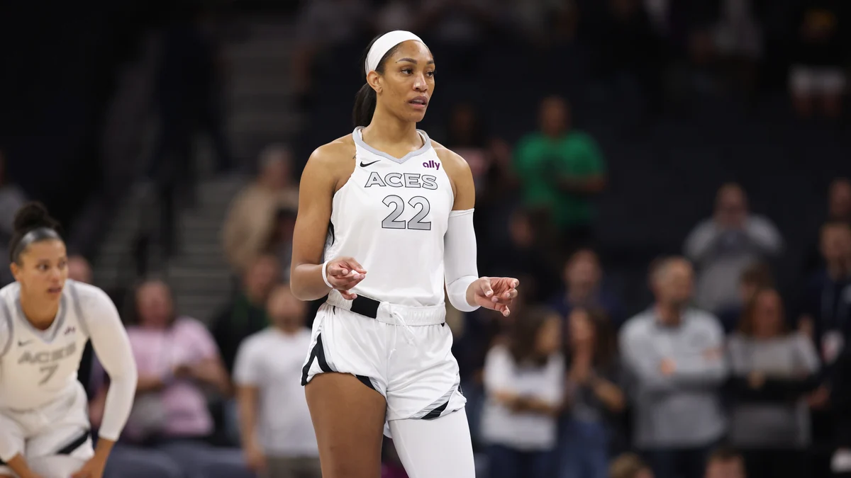 A’ja Wilson stands on the court in the Las Vegas Aces’ white No. 22 uniform.