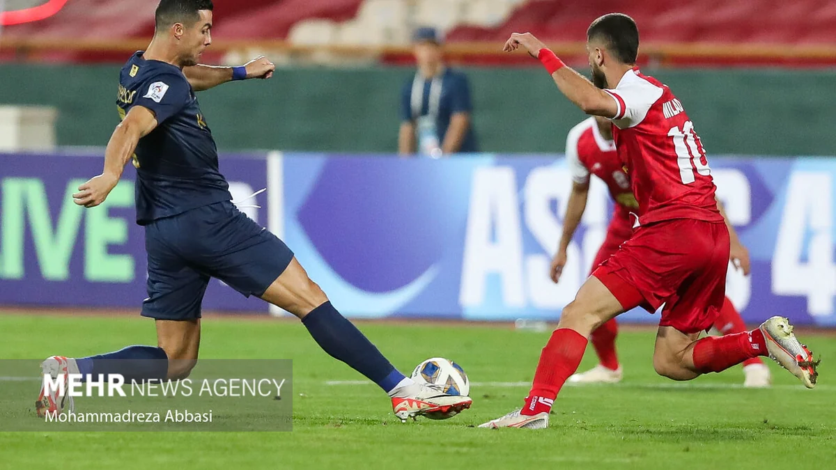 Un joueur d’Al-Nassr frappe le ballon devant un défenseur de Persepolis