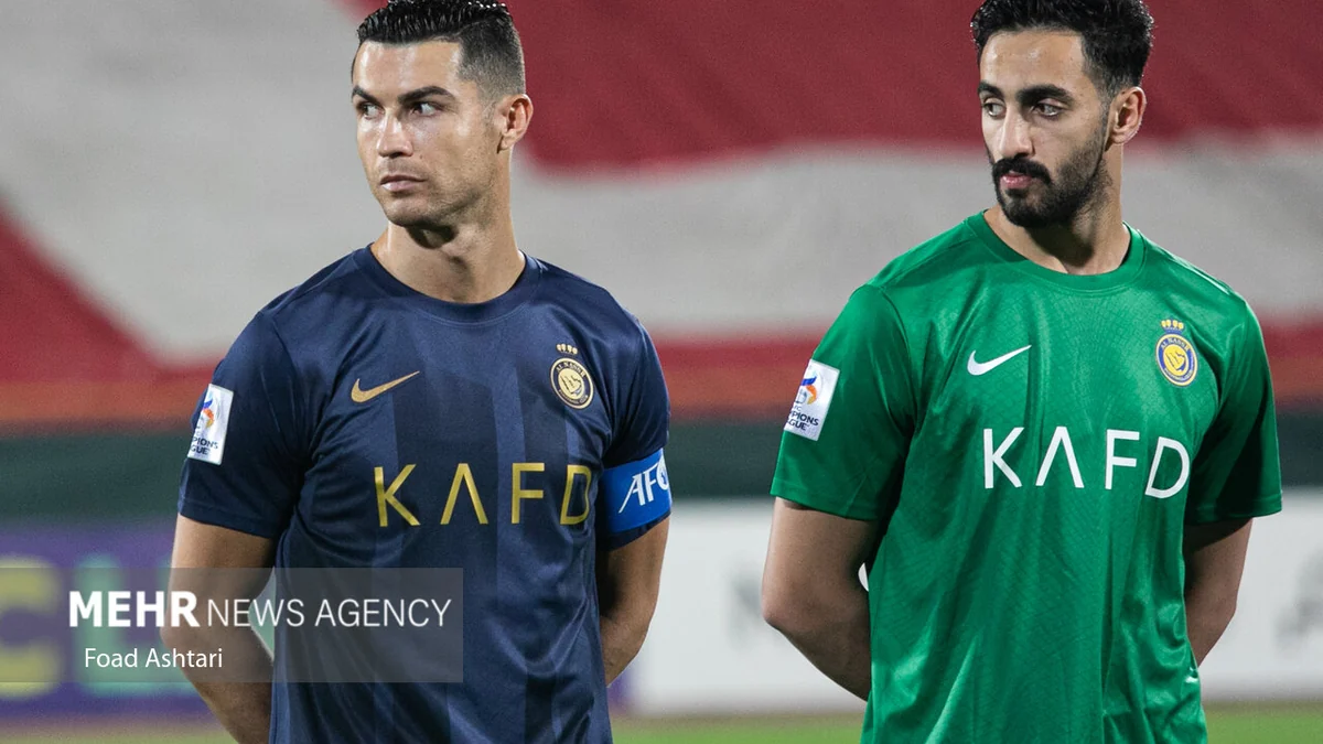 Cristiano Ronaldo com a camisa azul do Al-Nassr ao lado de um goleiro de uniforme verde.
