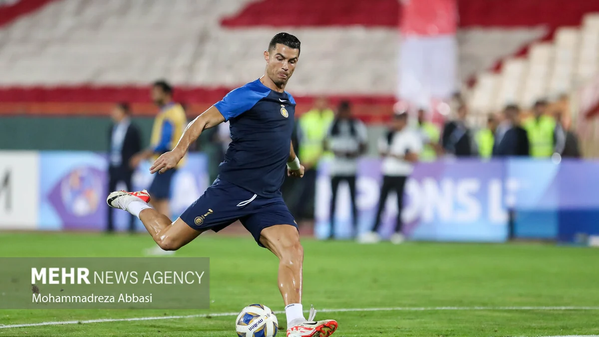 Cristiano Ronaldo chuta uma bola no gramado com o uniforme azul de treino do Al-Nassr.
