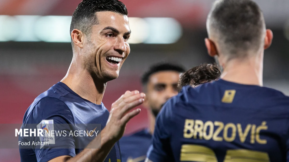 Cristiano Ronaldo sorri diante de Marcelo Brozović, visto de costas com a camisa do Al-Nassr.