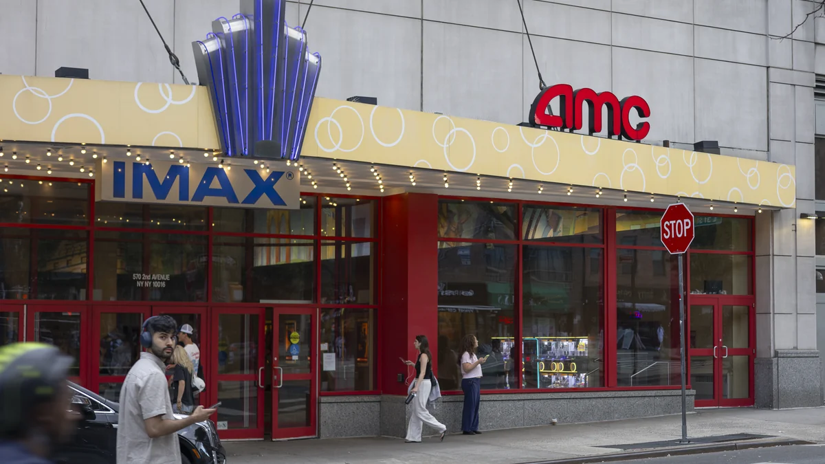 Entrada do AMC Kips Bay 15 com letreiros IMAX e AMC, portas vermelhas e pedestres na calçada
