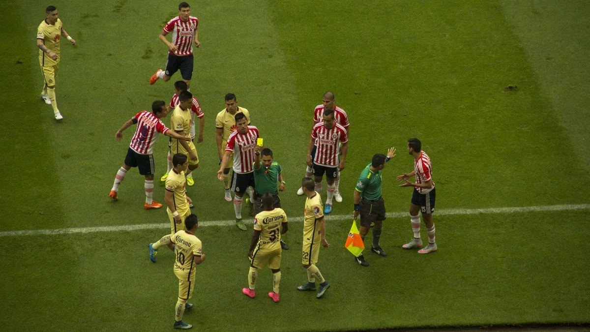 Jogadores de América e Guadalajara cercam a equipe de arbitragem no campo