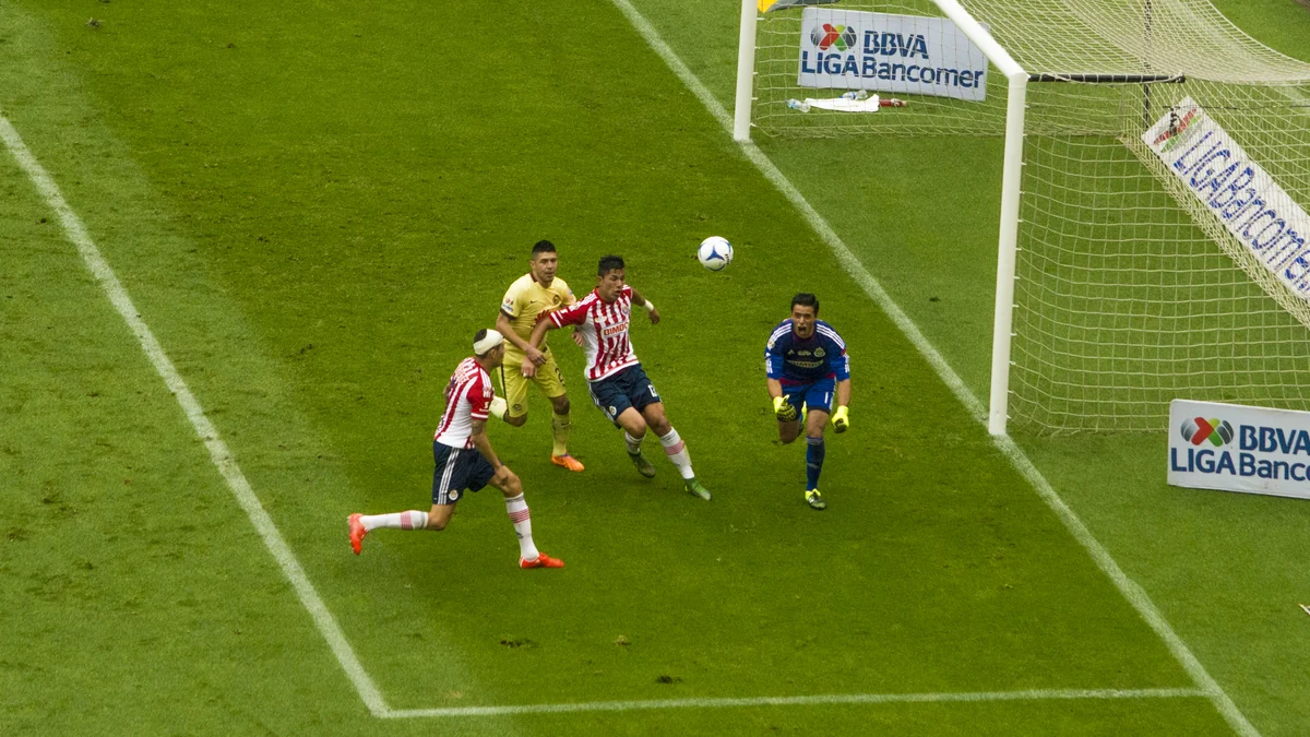 Jogadores de América e Guadalajara disputam uma bola aérea diante do gol