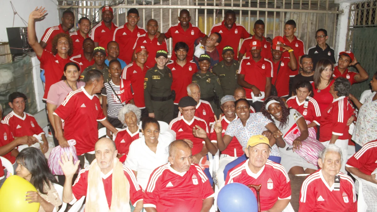 Group of players and community members wearing red América de Cali shirts