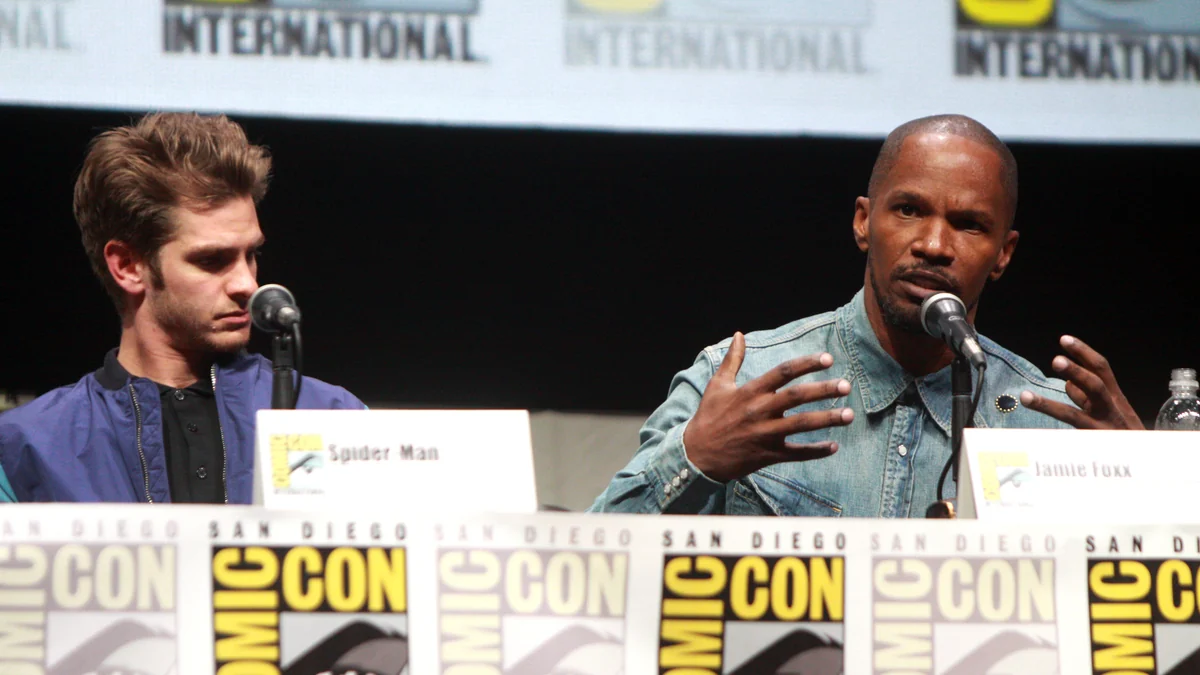 Andrew Garfield observa a Jamie Foxx mientras habla ante un micrófono en un panel de la Comic-Con.