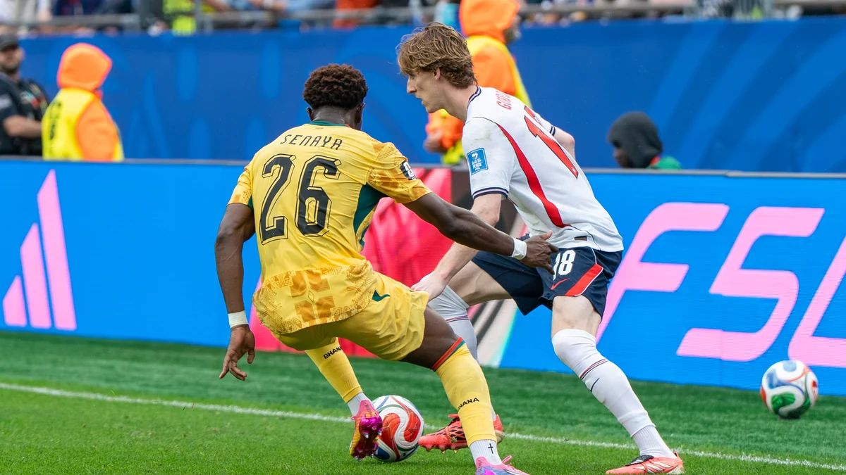 Anthony Gordon contests the ball with Marvin Senaya near the touchline.