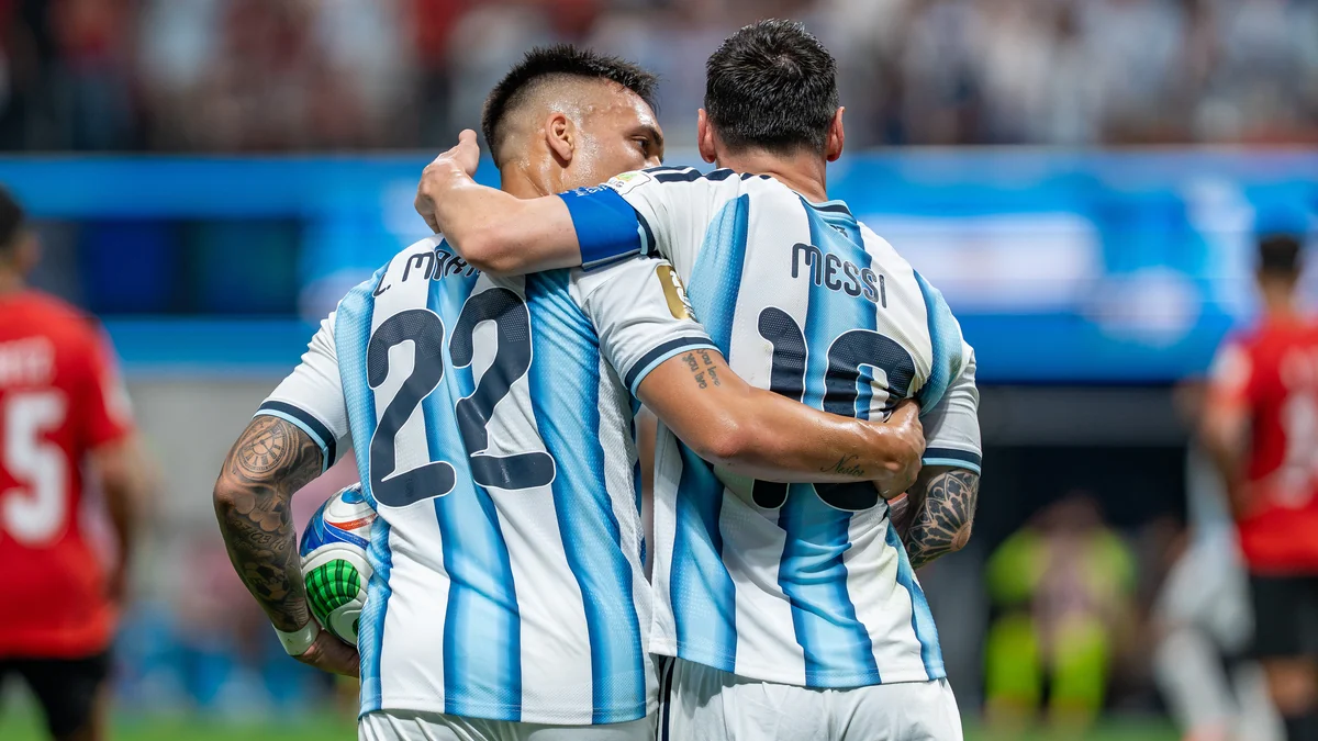 Lionel Messi e Lautaro Martínez se abraçam de costas com as camisas da Argentina