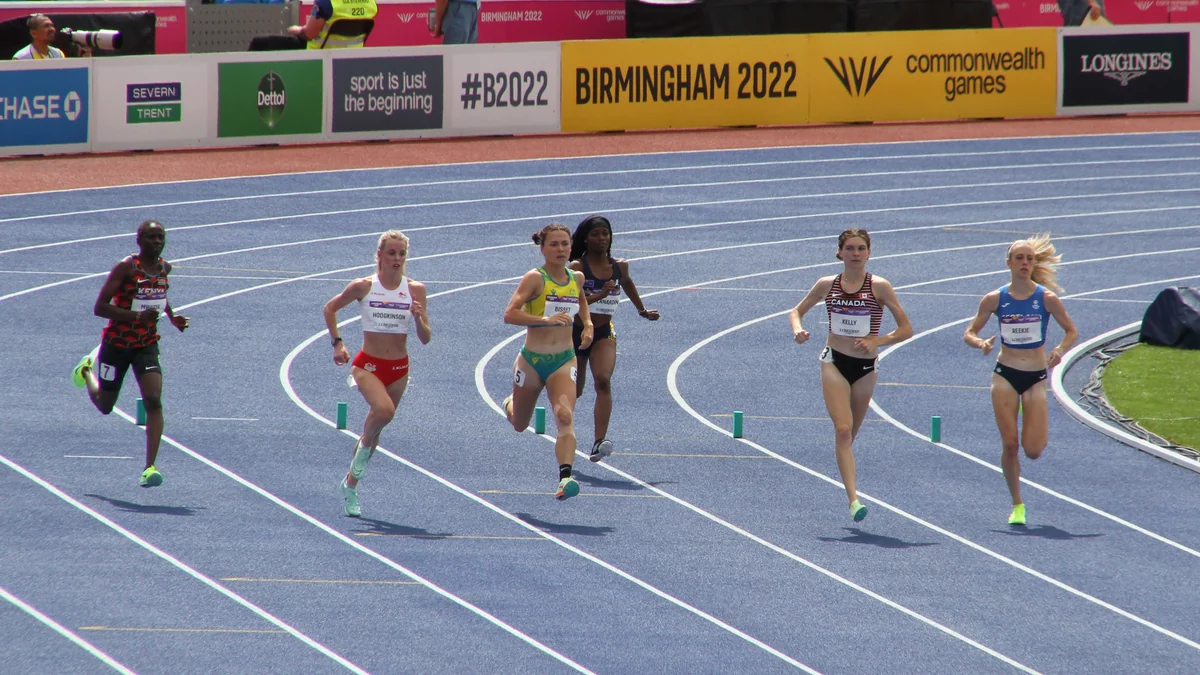 Seis atletas disputam uma corrida feminina em uma pista azul, com Keely Hodgkinson de vermelho