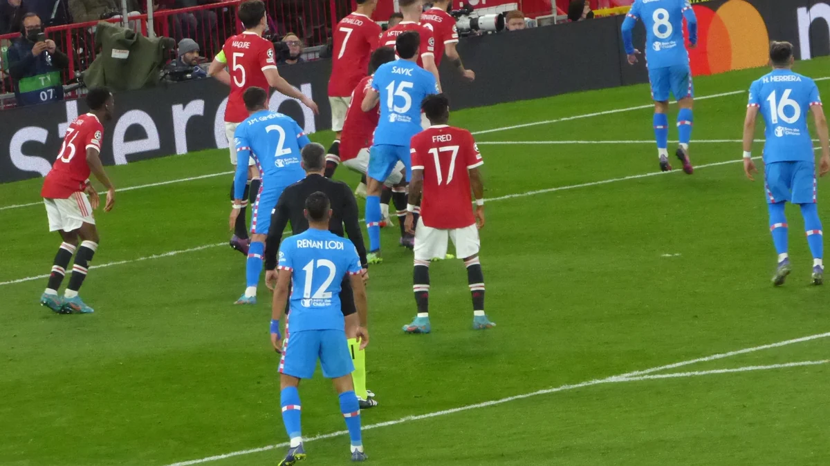 Jogadores de Manchester United e Atlético de Madrid se posicionam perto da área durante uma bola parada
