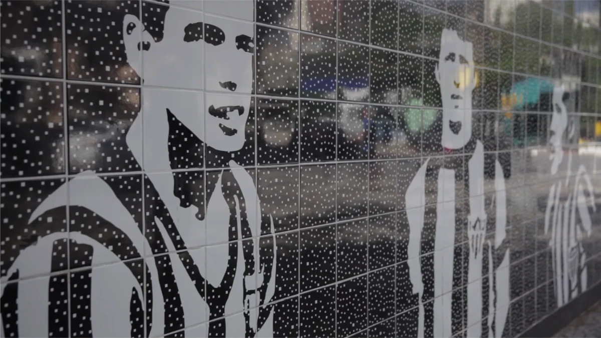 Black-and-white tiled mural depicting football players