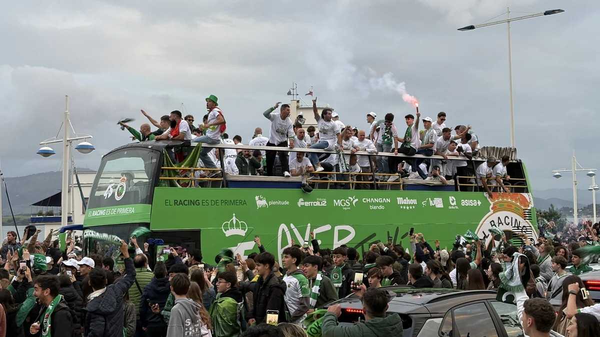 Racing players and supporters celebrate around a green open-top bus