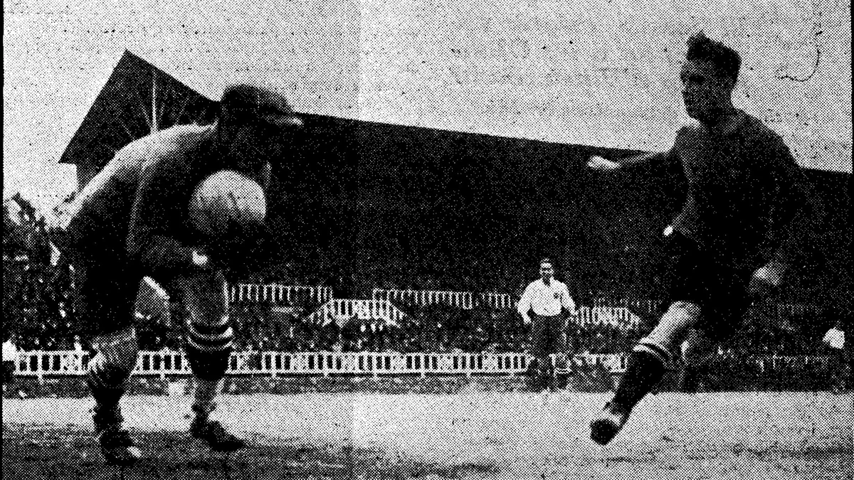 Fotografia histórica em preto e branco de um jogador cabeceando a bola diante de um adversário durante uma partida de futebol.