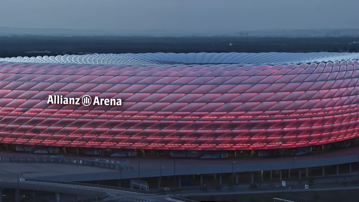 Allianz Arena facade partly illuminated red at dusk