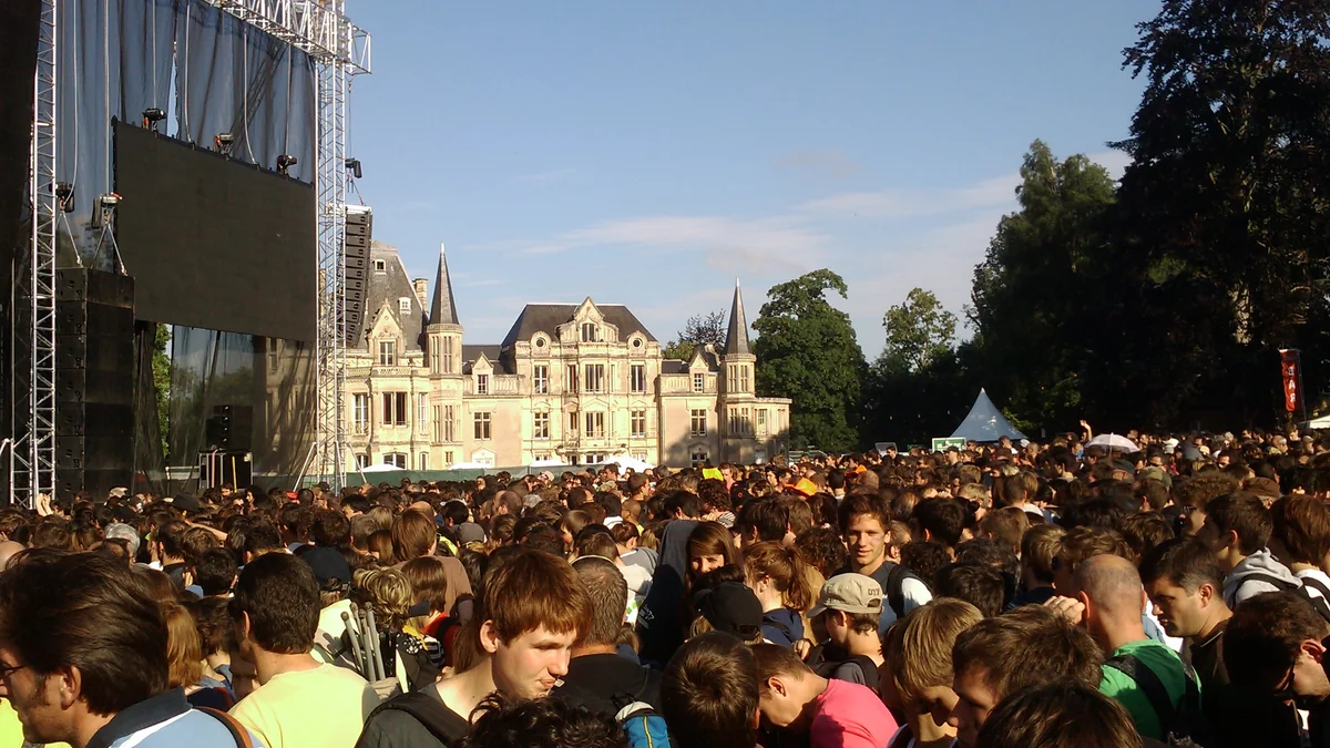 Large crowd gathered between a festival stage and the Château de Beauregard
