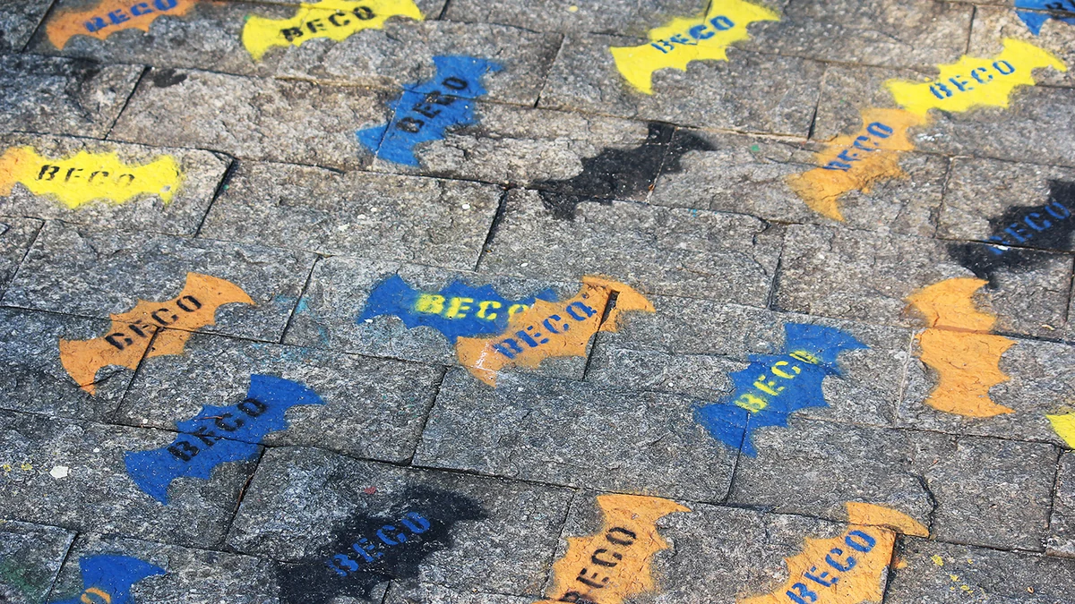 Pavimento de piedra con siluetas de murciélagos de colores y la palabra Beco