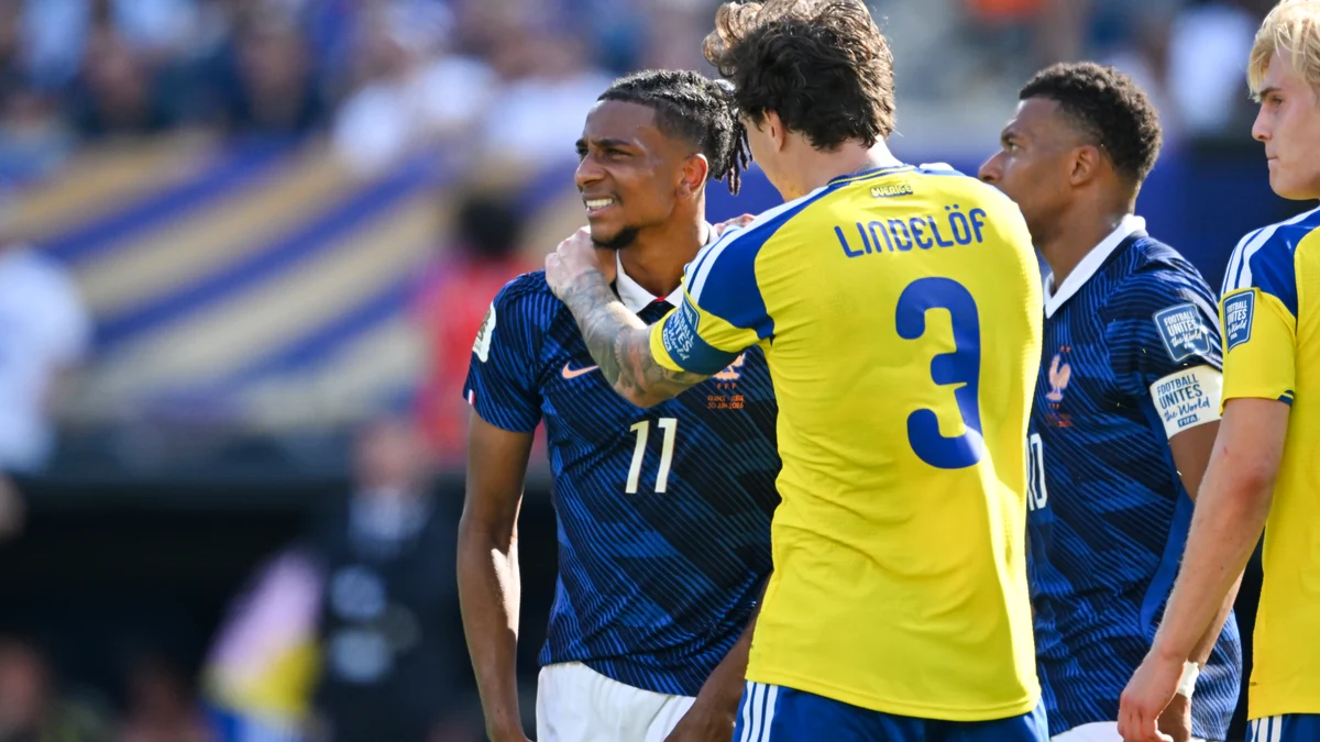 Michael Olise, com a camisa 11 da França, diante de Victor Lindelöf em campo