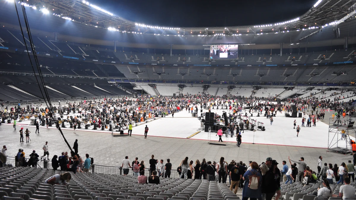 Stade de France floor filled with musical equipment, platforms and people after an event