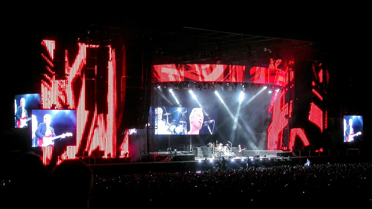 Concert stage lit in red before a crowd at Stade de France at night