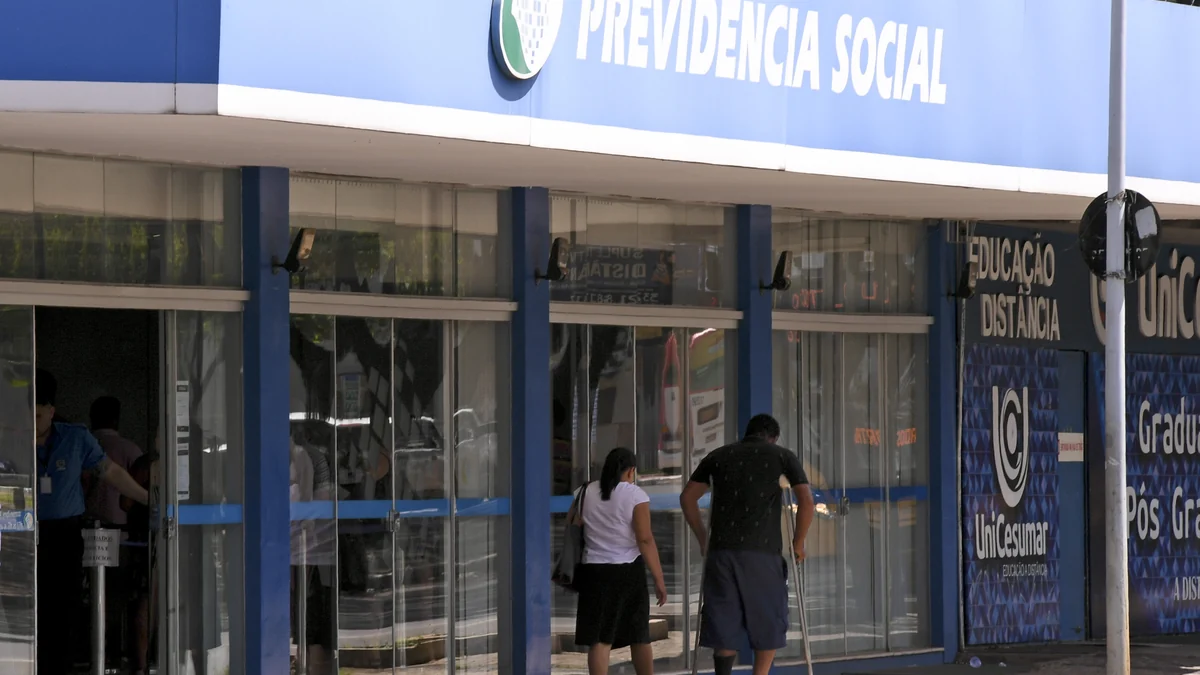 Façade d’une agence de la Sécurité sociale brésilienne avec deux personnes près de l’entrée