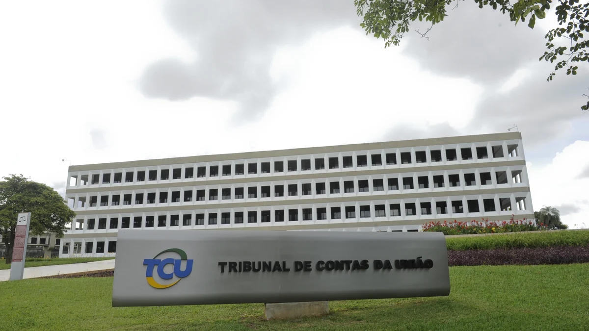 Fachada do Tribunal de Contas da União com placa do TCU diante do edifício