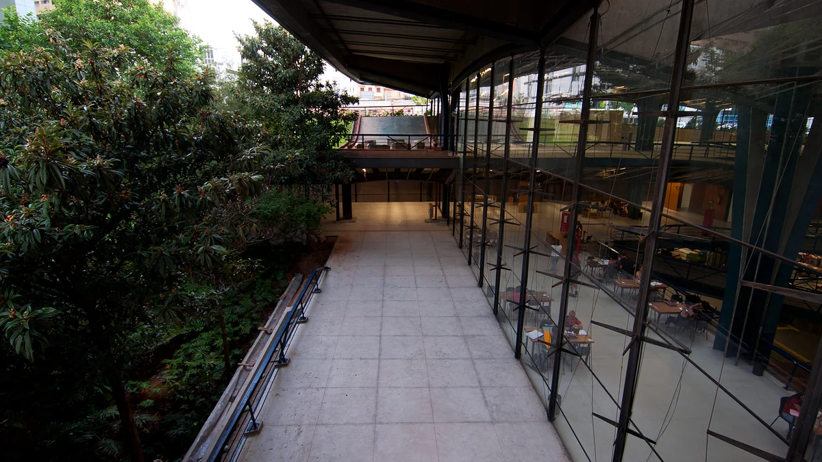 Árboles junto a una pasarela y una pared de vidrio del Centro Cultural São Paulo