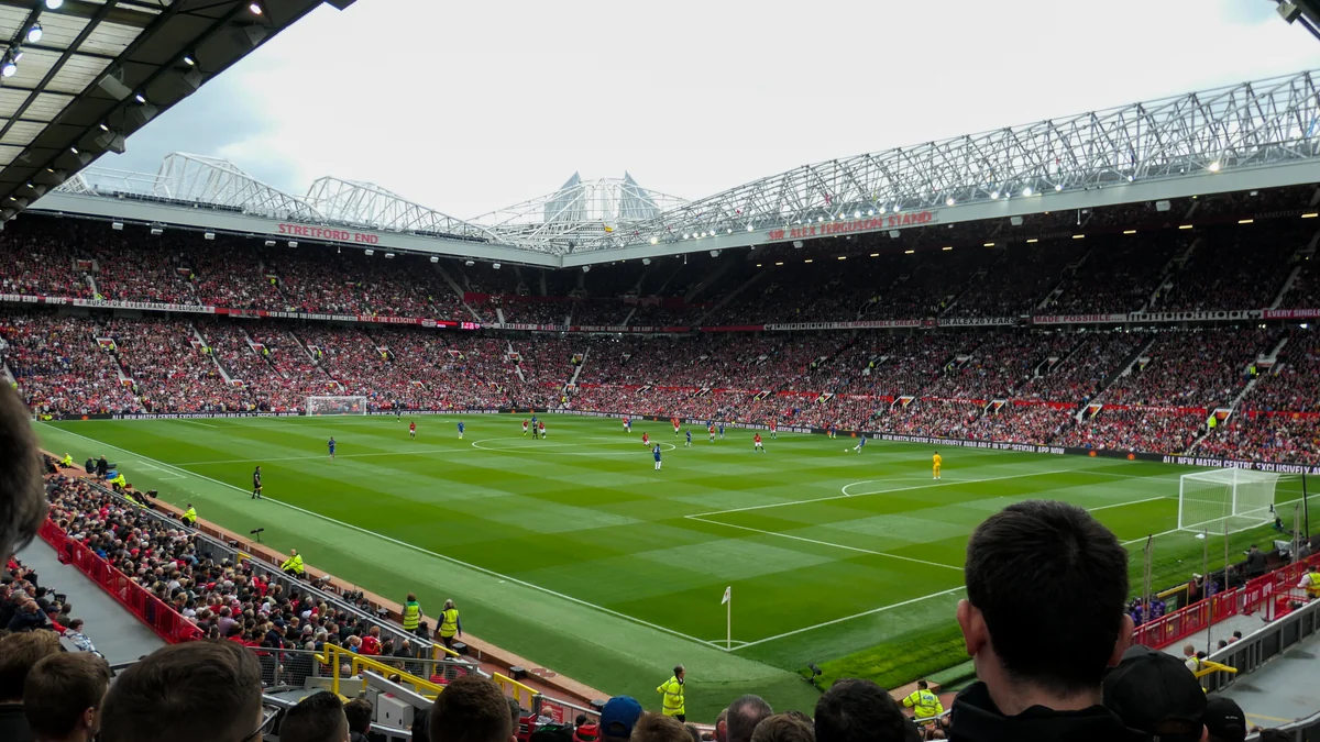 Vista panorámica de un estadio lleno durante un partido entre jugadores de rojo y azul.
