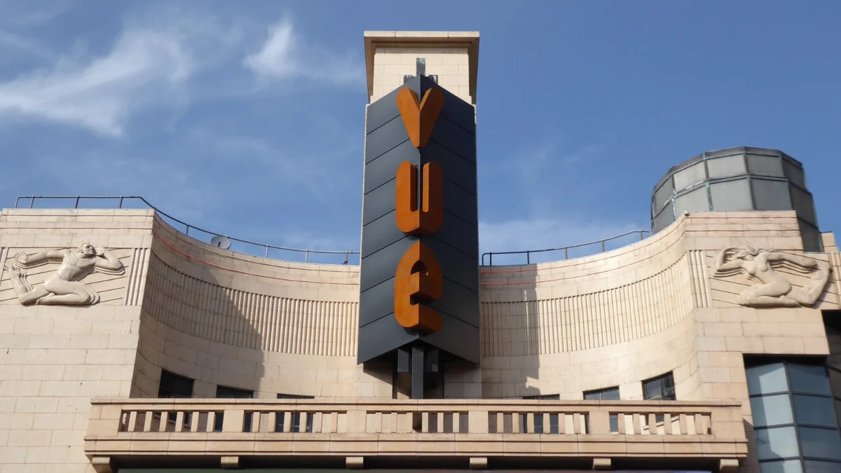 Façade incurvée en pierre d’un cinéma avec une enseigne verticale Vue