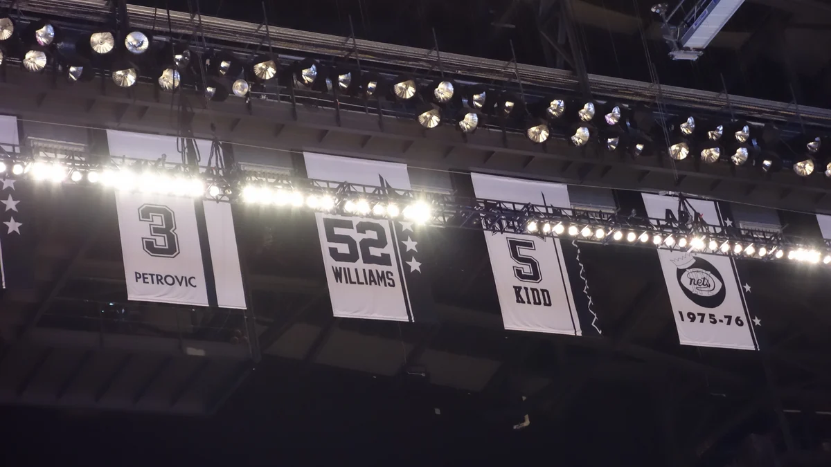 Nets retired-number banners hanging beneath the lights at Barclays Center