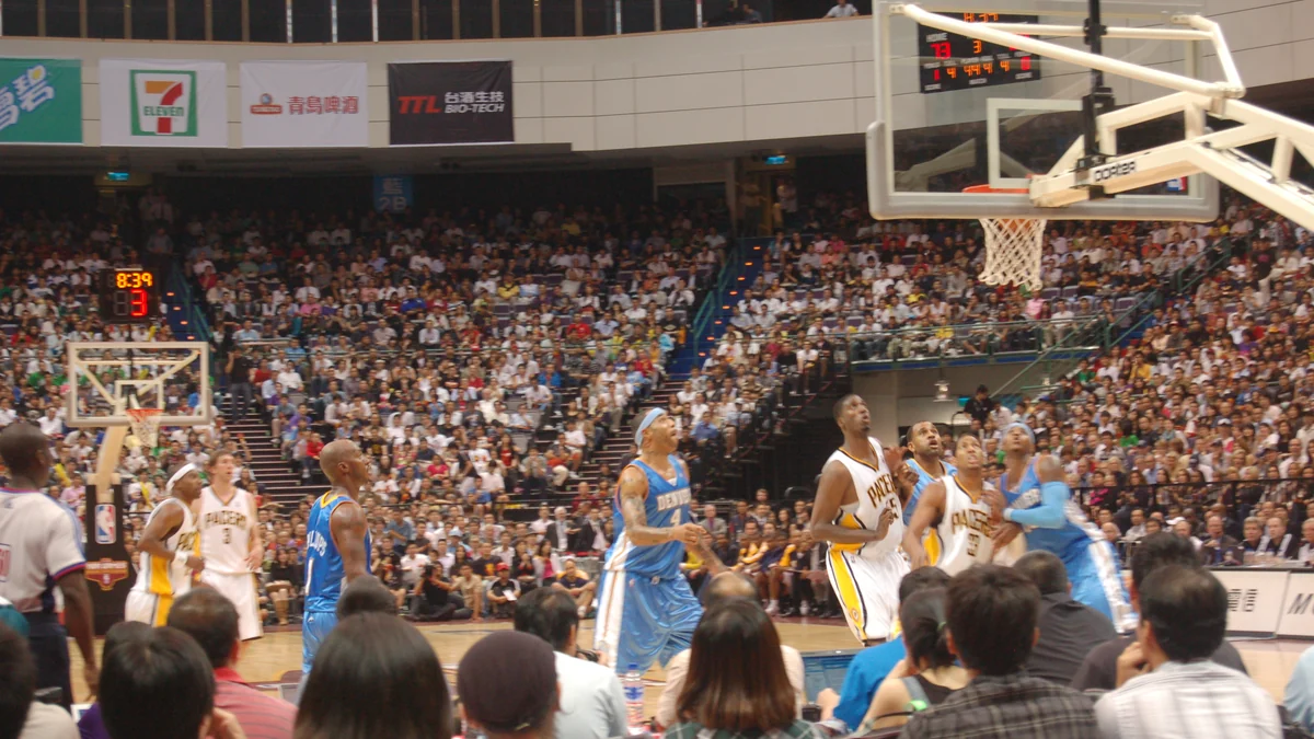 Denver Nuggets and Indiana Pacers players wait for a rebound under the basket