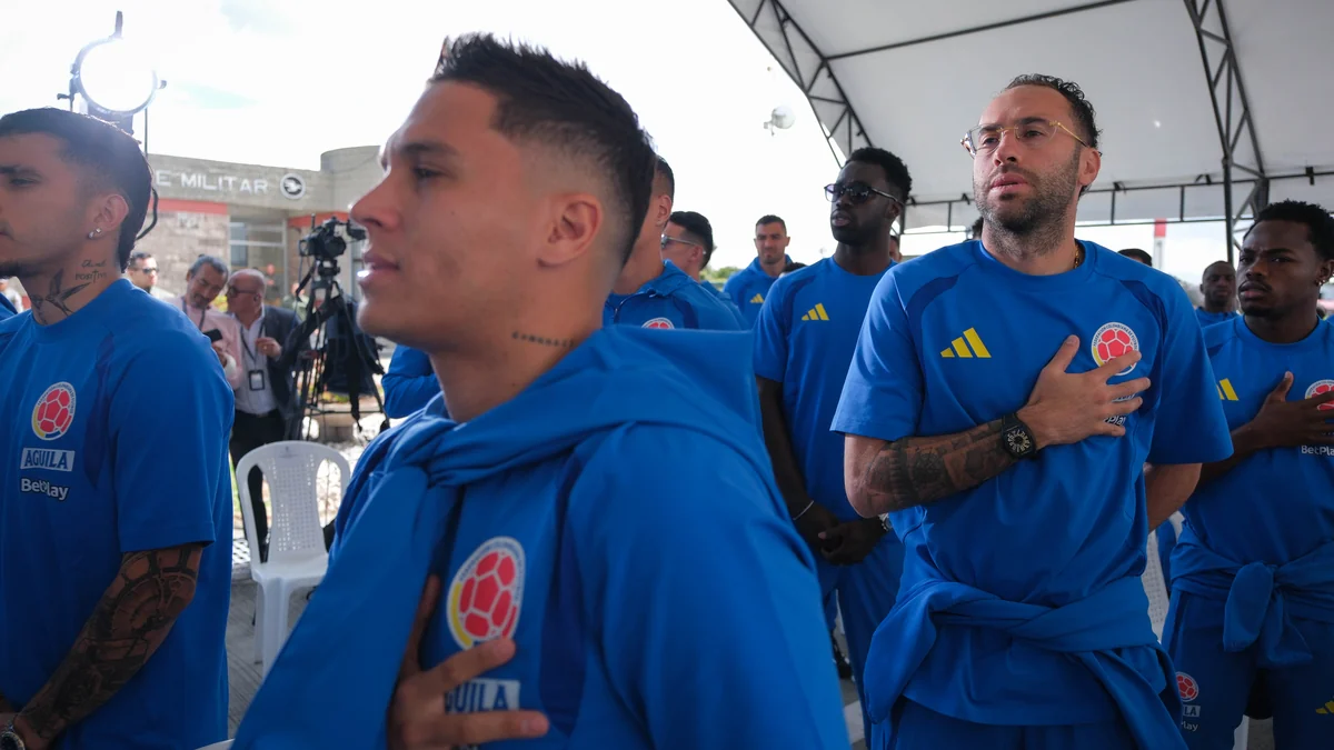 Joueurs de la sélection colombienne en tenue bleue, certains avec la main sur la poitrine