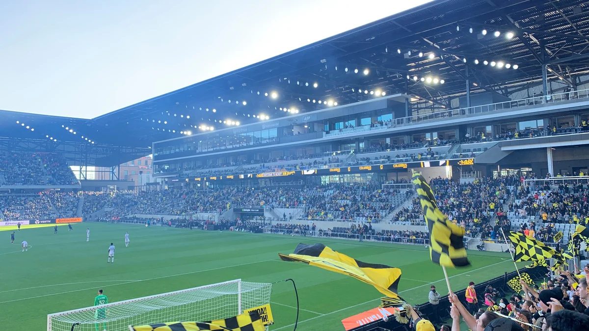 Stand filled with supporters and yellow-and-black flags at a Columbus Crew match