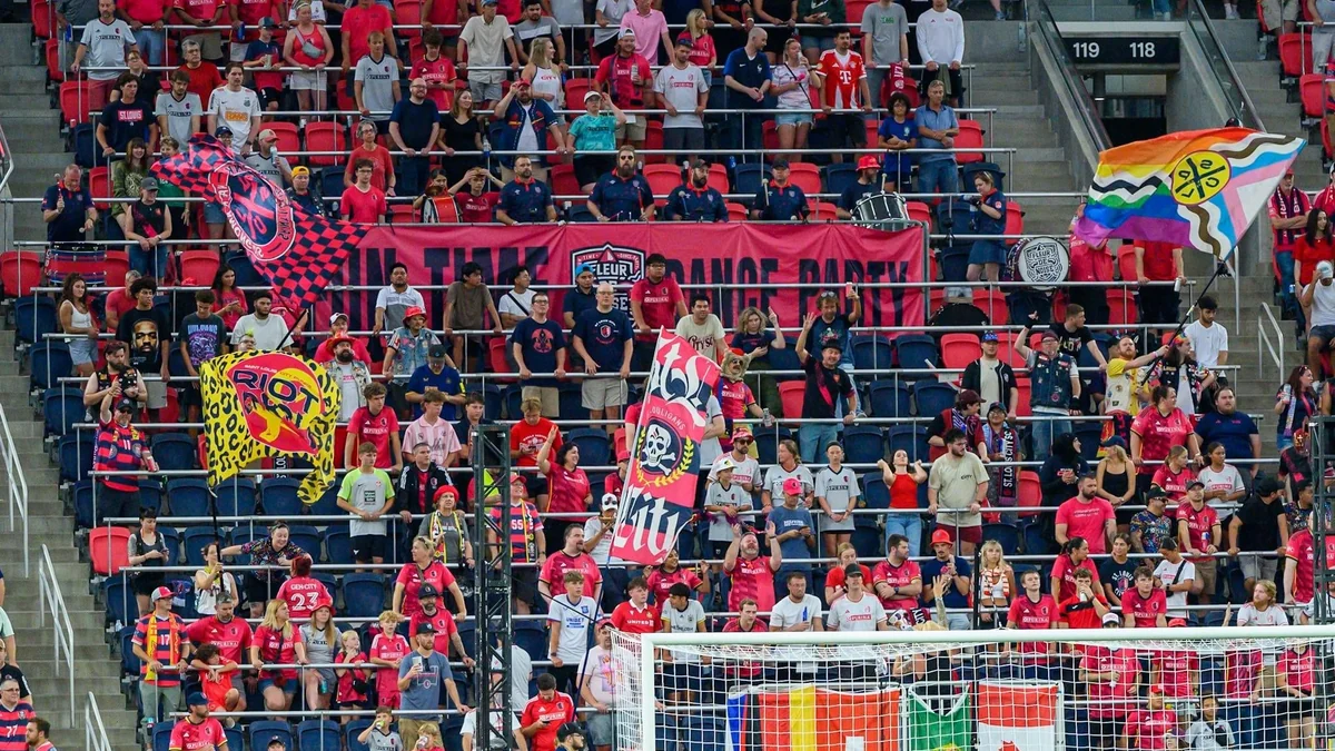 St. Louis CITY supporters in the stands with red shirts, banners and flags