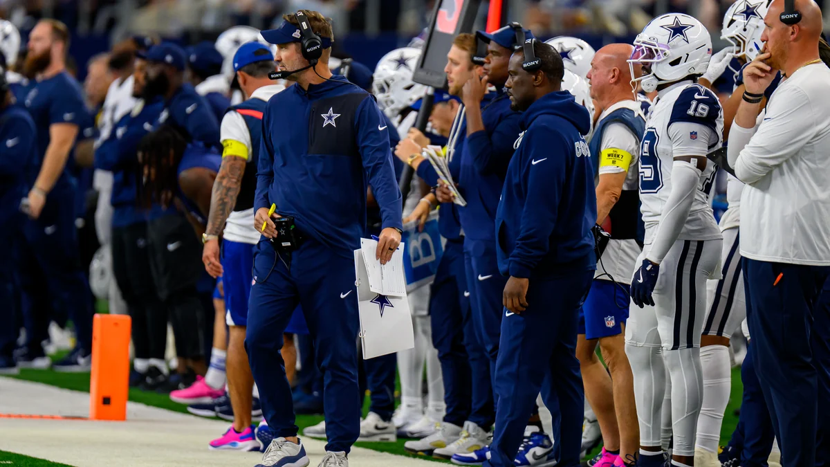 Entrenadores y jugadores de Dallas Cowboys observan el partido desde la banda.