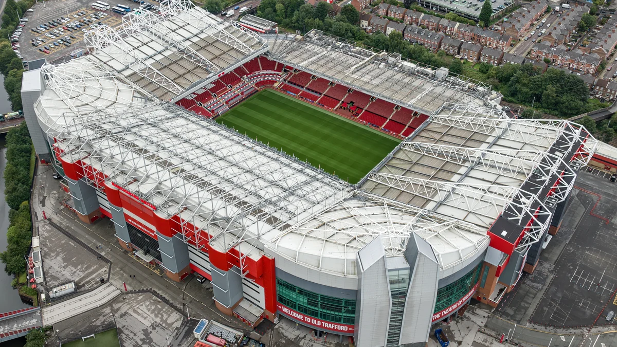 Vista aérea de Old Trafford, com arquibancadas vermelhas e o campo ao centro