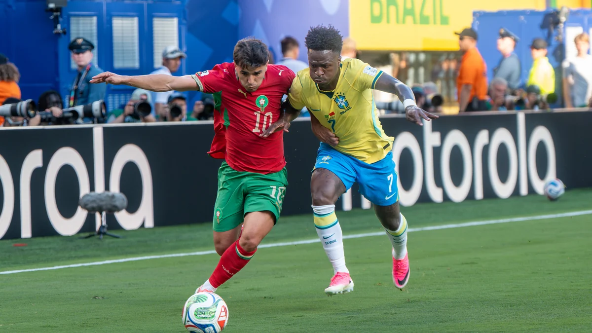 Vinícius Júnior challenges a Morocco player for the ball near the touchline