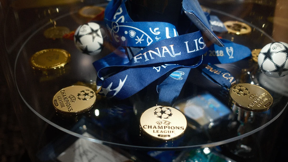 Gold Champions League medals among blue ribbons and small star-patterned footballs