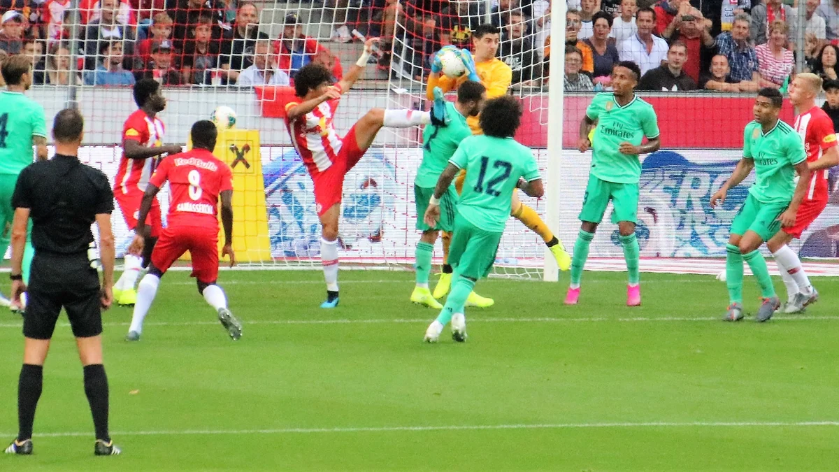 Courtois, en jaune, dispute un ballon aérien devant son but contre le RB Salzbourg