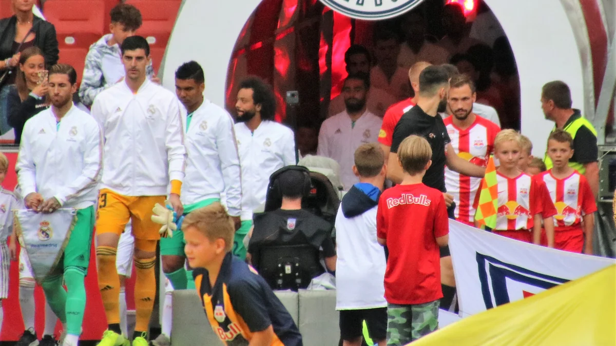 Thibaut Courtois, vêtu de blanc, marche avec des joueurs du Real Madrid à la sortie du tunnel