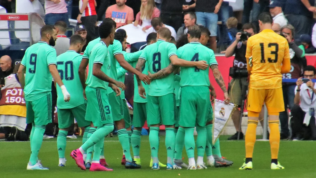 Courtois, en tenue jaune floquée du numéro 13, se tient près des joueurs du Real Madrid réunis sur le terrain