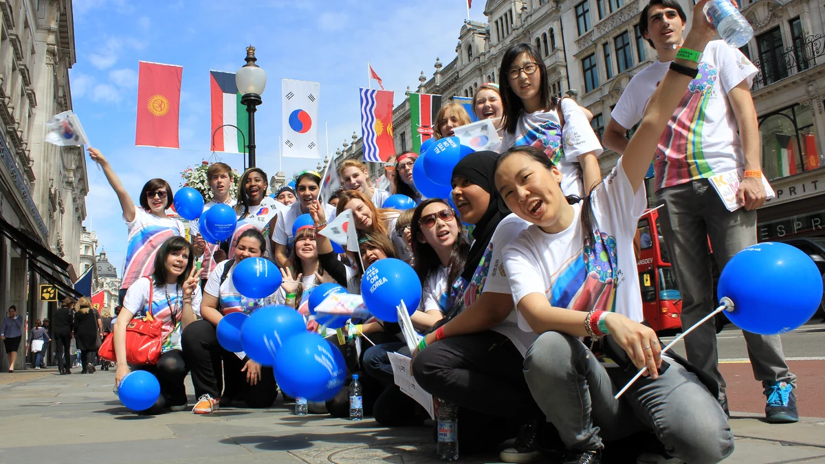 Un grupo posa con globos azules y pequeñas banderas surcoreanas en una calle de Londres