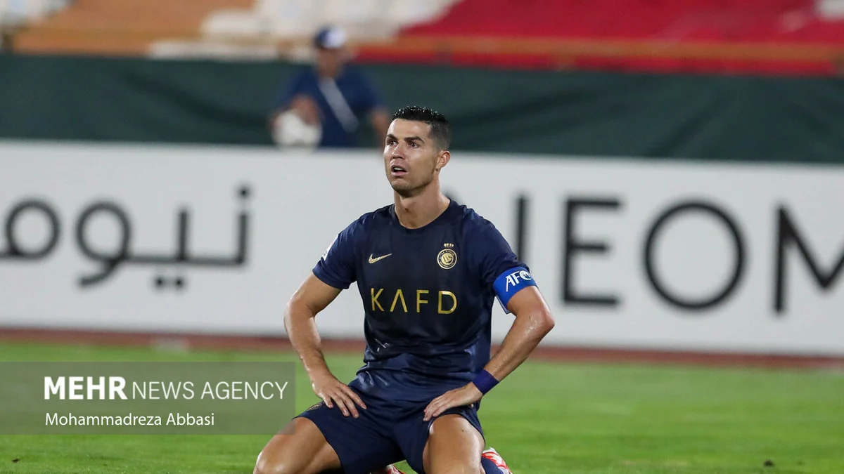 Cristiano Ronaldo à genoux sur la pelouse, les mains sur la taille, avec la tenue d’Al-Nassr