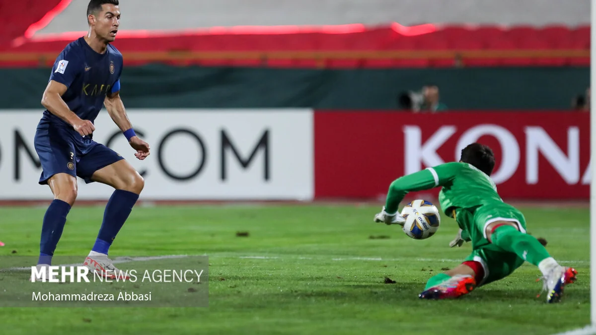 Cristiano Ronaldo avance vers un gardien en vert qui tient le ballon au sol