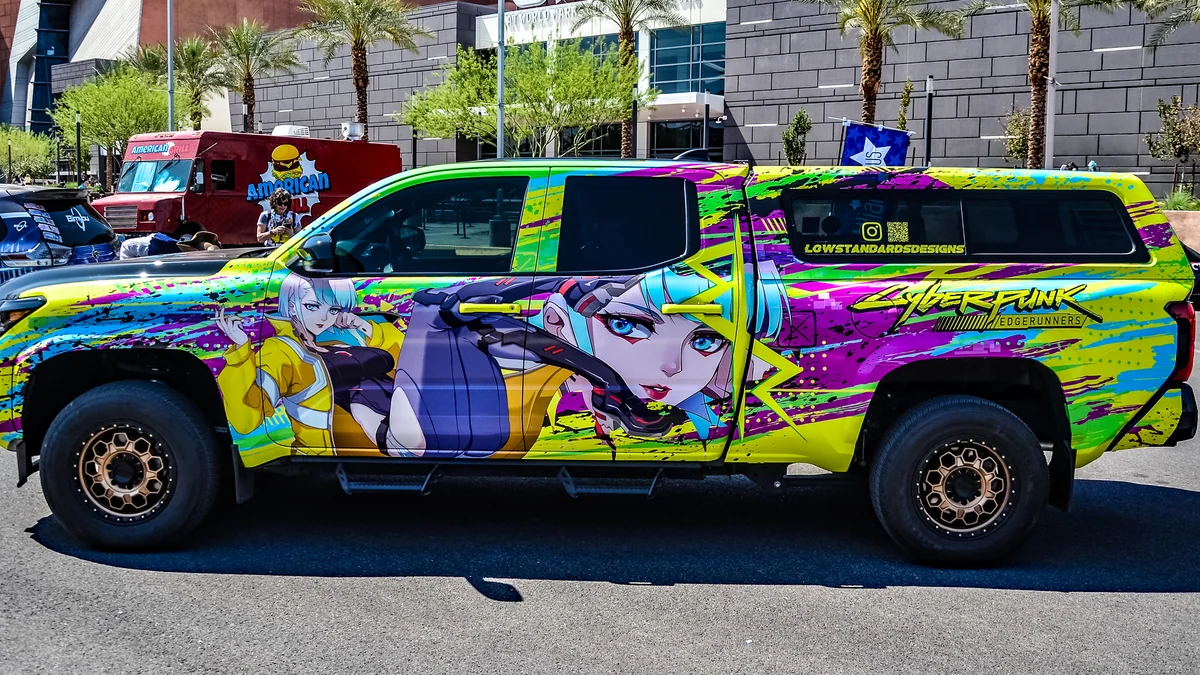 Vue latérale d’un pick-up vert, rose et jaune avec des personnages et le logo Cyberpunk: Edgerunners