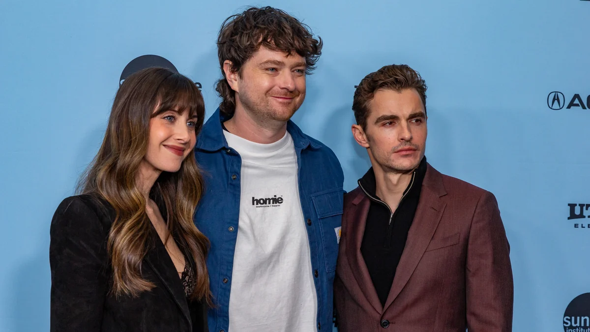 Alison Brie, Michael Shanks e Dave Franco posam lado a lado diante de um painel azul.