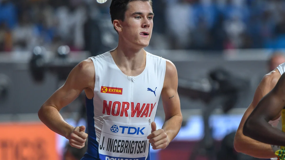 Jakob Ingebrigtsen runs in Norway’s white uniform on an athletics track.